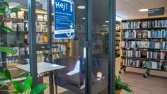 I biblioteksrummet finns ett glasrum för max två personer där man kan plugga eller läsa ifred. Två sittfåtöljer står mitt emot varandra i glasrummet med ett vitt litet bord emellan.