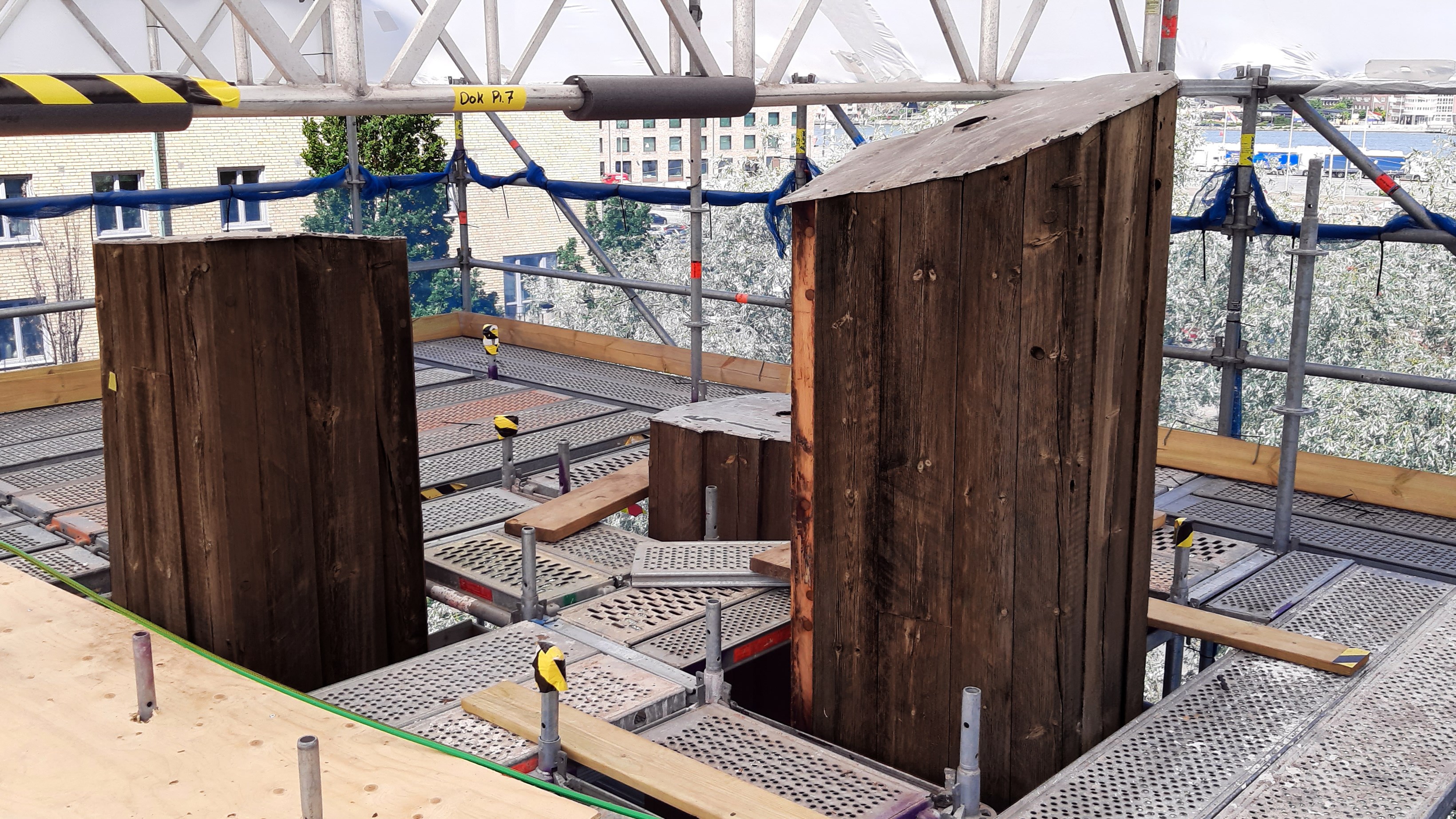 Toppen på masterna på Masthuggstorget sticker upp ovanför en byggnadsställning.