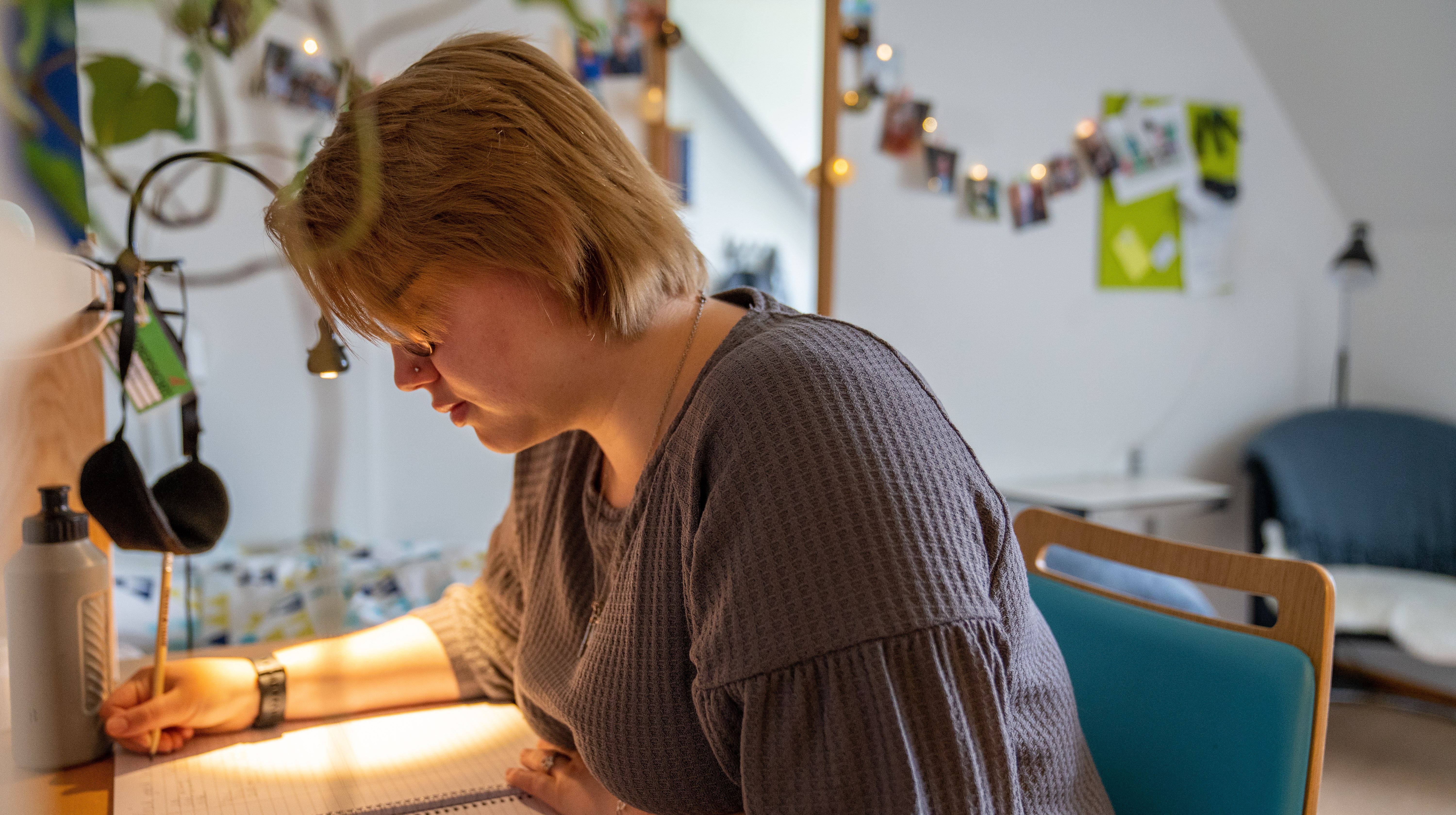 Interiörbild där elev sitter vid skrivbordet i sitt rum