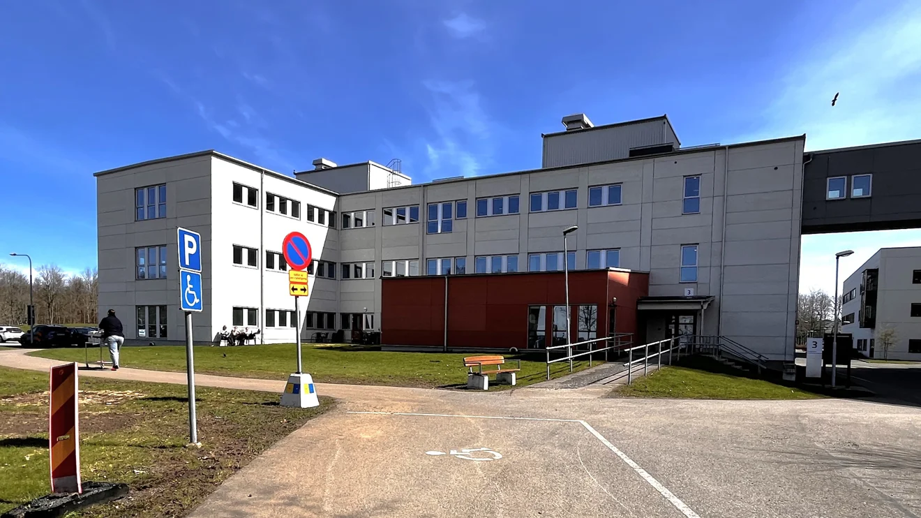 Vitt hus med orangebrun utbyggnad vid entrén.