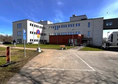 Vitt hus med orangebrun utbyggnad vid entrén.