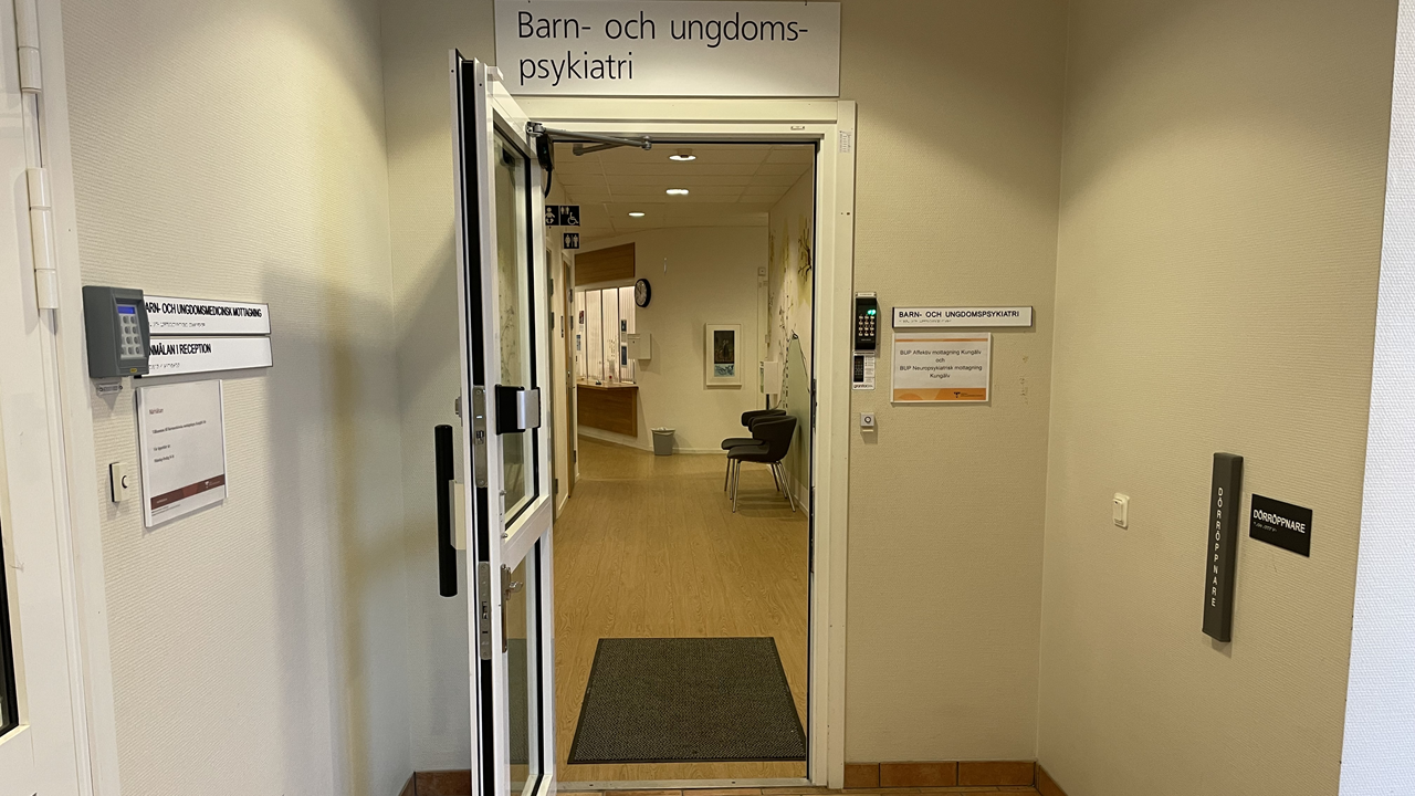 En öppen dörr. Ovanför hänger en skylt där det står "Barn- och ungdomspsykiatri"