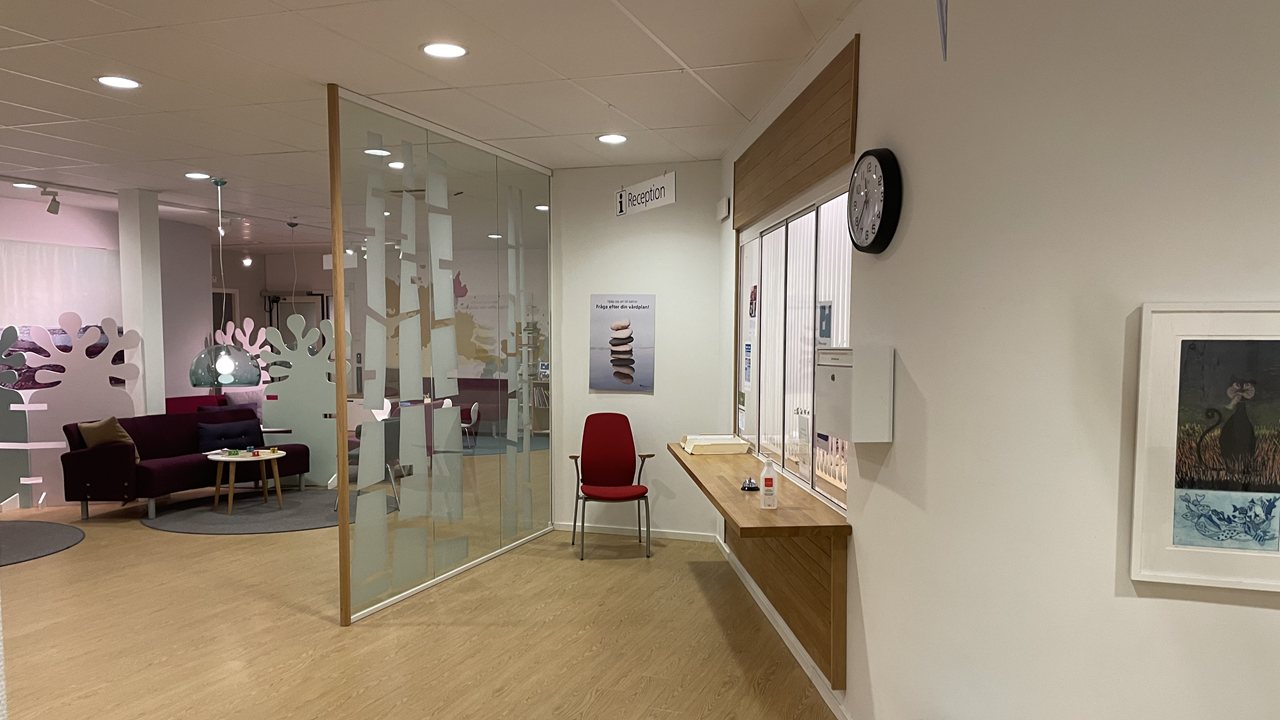 Del av väntrummet och receptionen sedd från sidan.