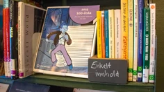 En närbild på en hylla i en bokhylla. En skylt på hyllan har texten "Enkelt innhold".