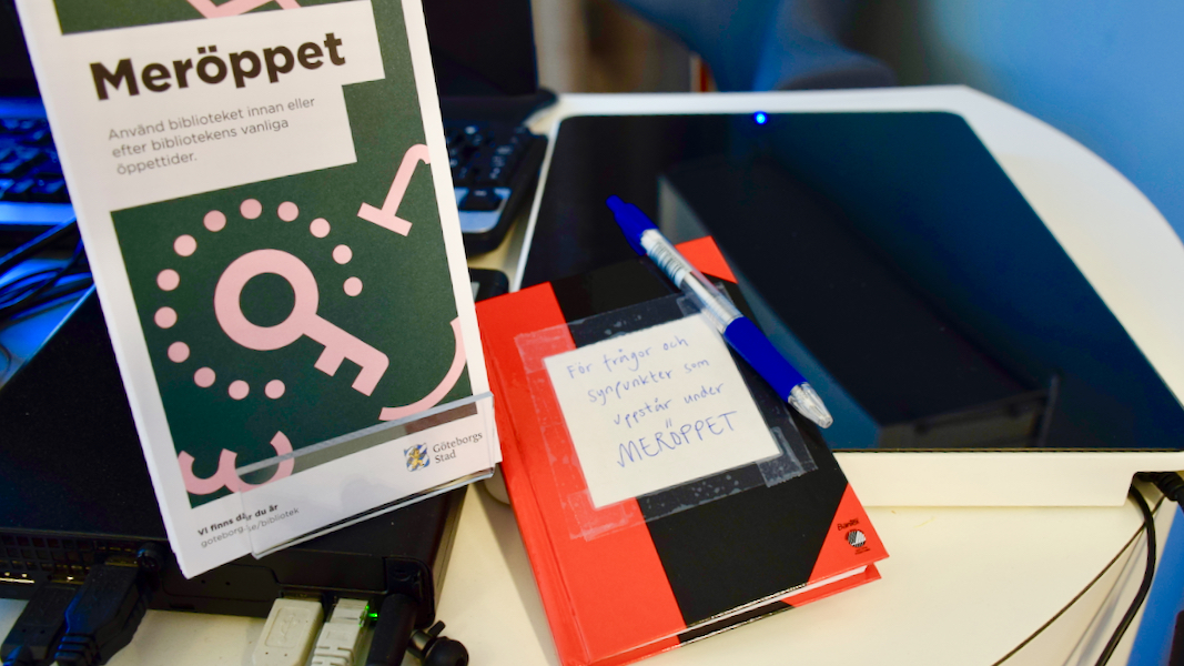 En liten skrivbok i svart och rött ligger på lånedisken. På den står det: För frågor och synpunkter som uppstår vid Meröppet".  