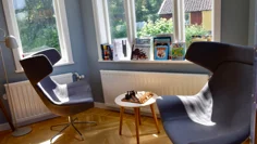 Två snurrfåtöljer står i ett burspråk. Mellan dem står ett schackspel.