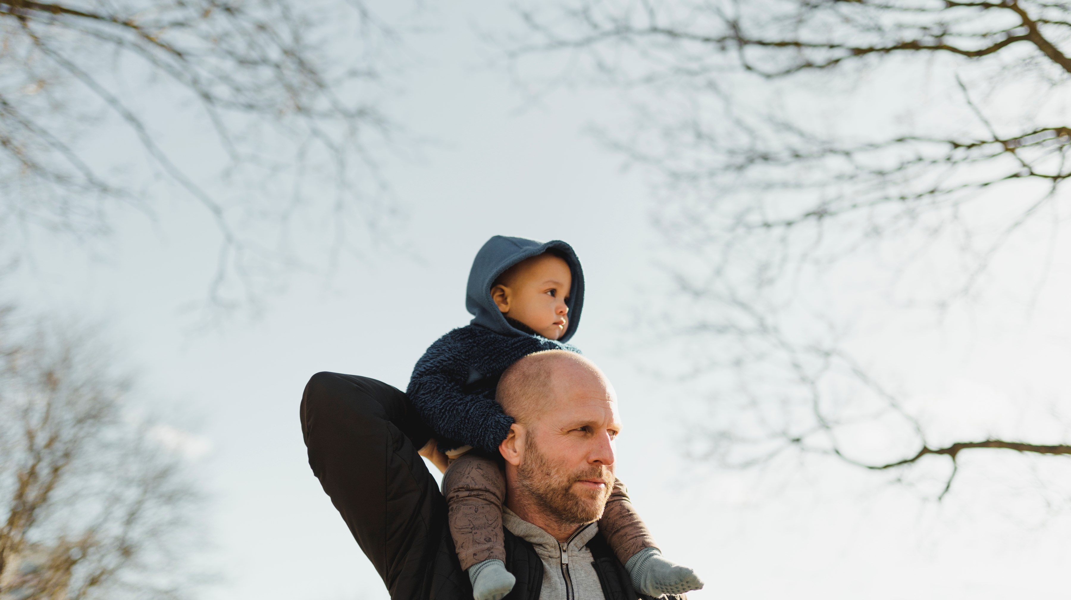 En person som bär ett litet barn på axlarna.