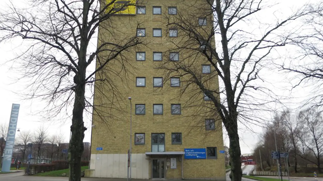 Hög gul tegelbyggnad med ingång på kortsidan